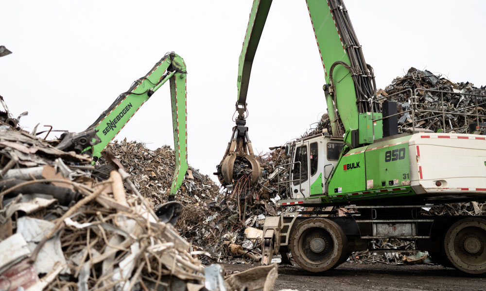 Green Sennebogen 850 Material Handler Lifting Steel Scraps