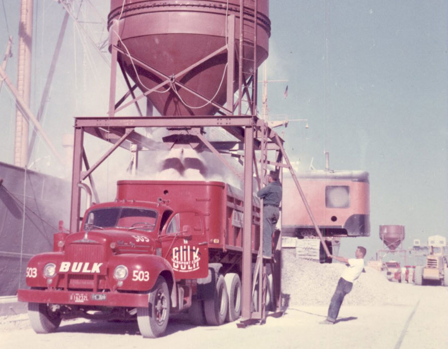 Bulk Team Members in Action Loading Material Onto a Red Dump Truck